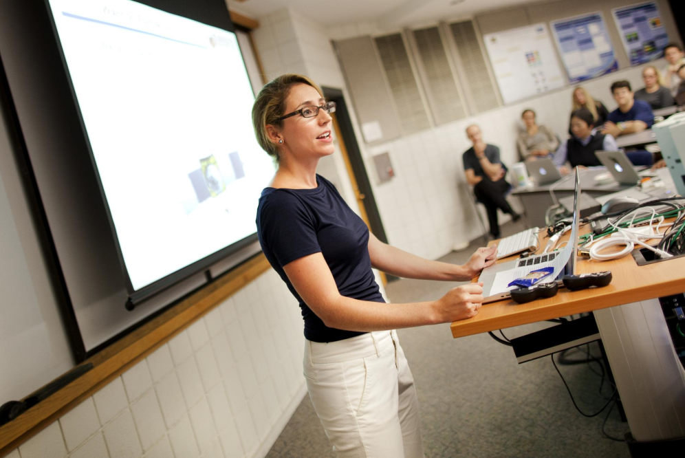 Speaker presenting to a room of academic community members
