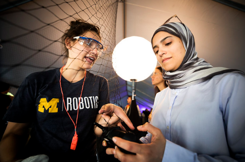 Robotics team member discussing project with other student
