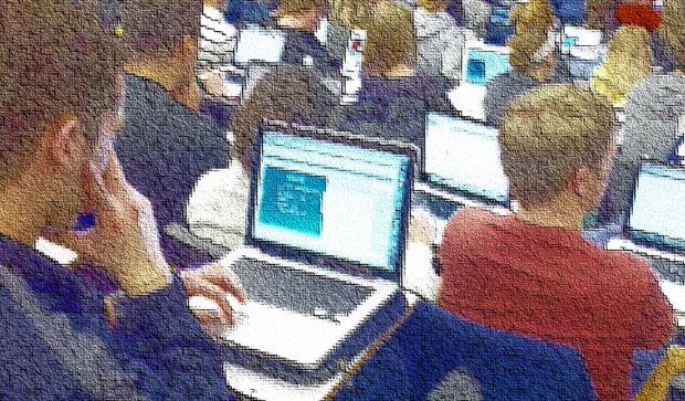 Students working on their laptops in a lecture hall