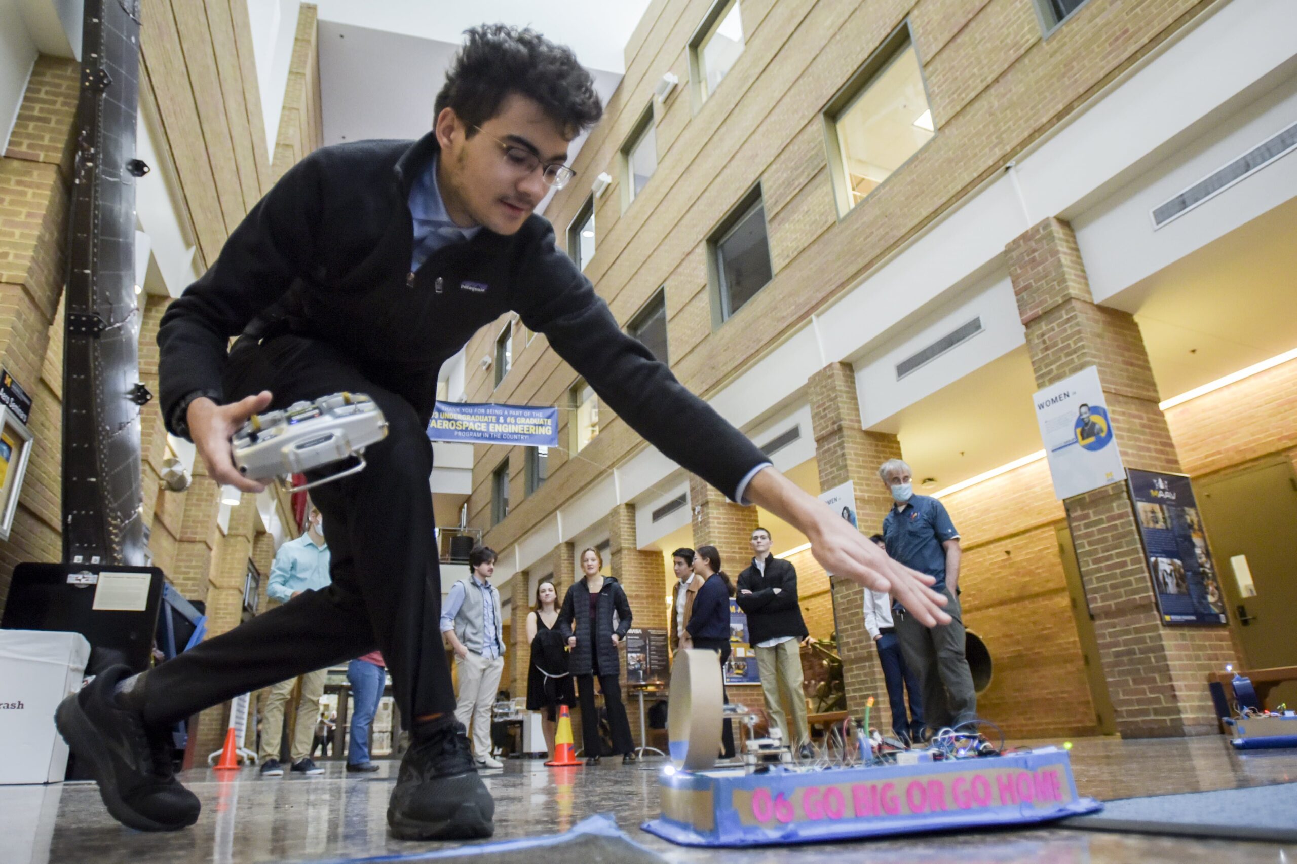 Student testing hovercraft vehicle with remote control