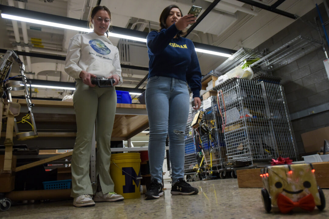 two students test controlling a robot car