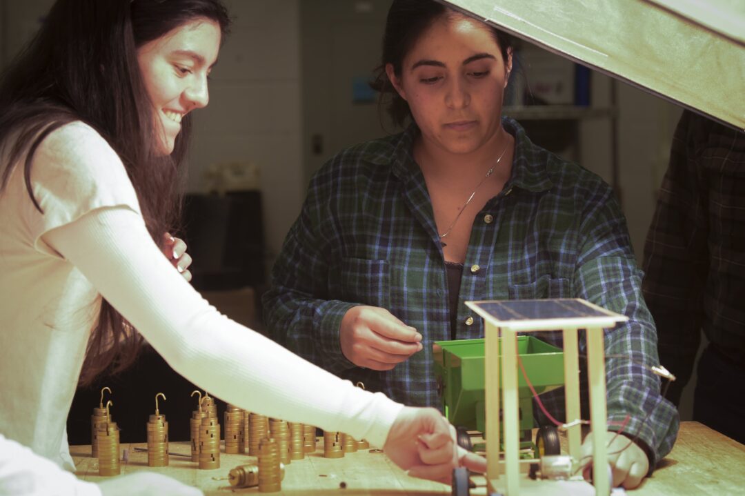 two students working on solar panel car