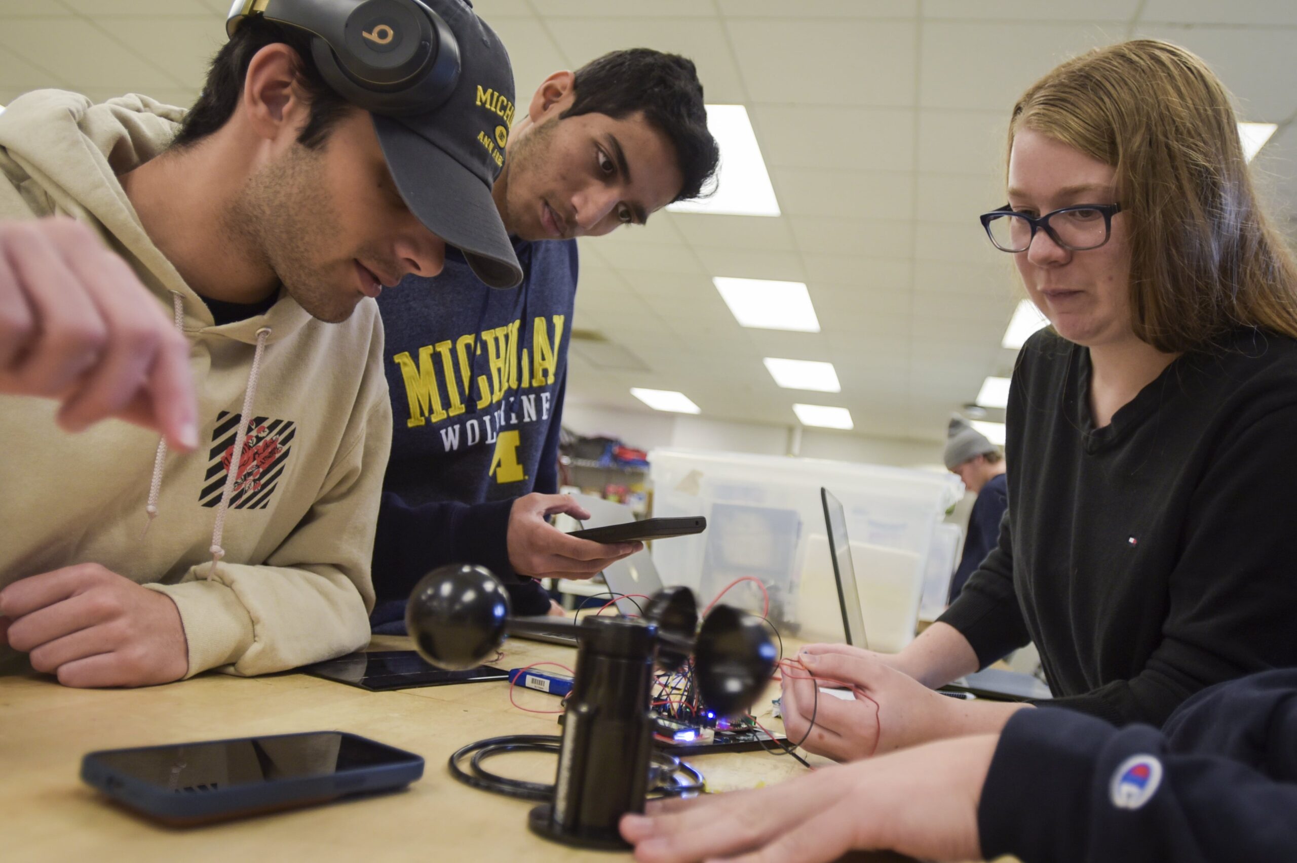 Students working together to connect electrical circuit to anemometer