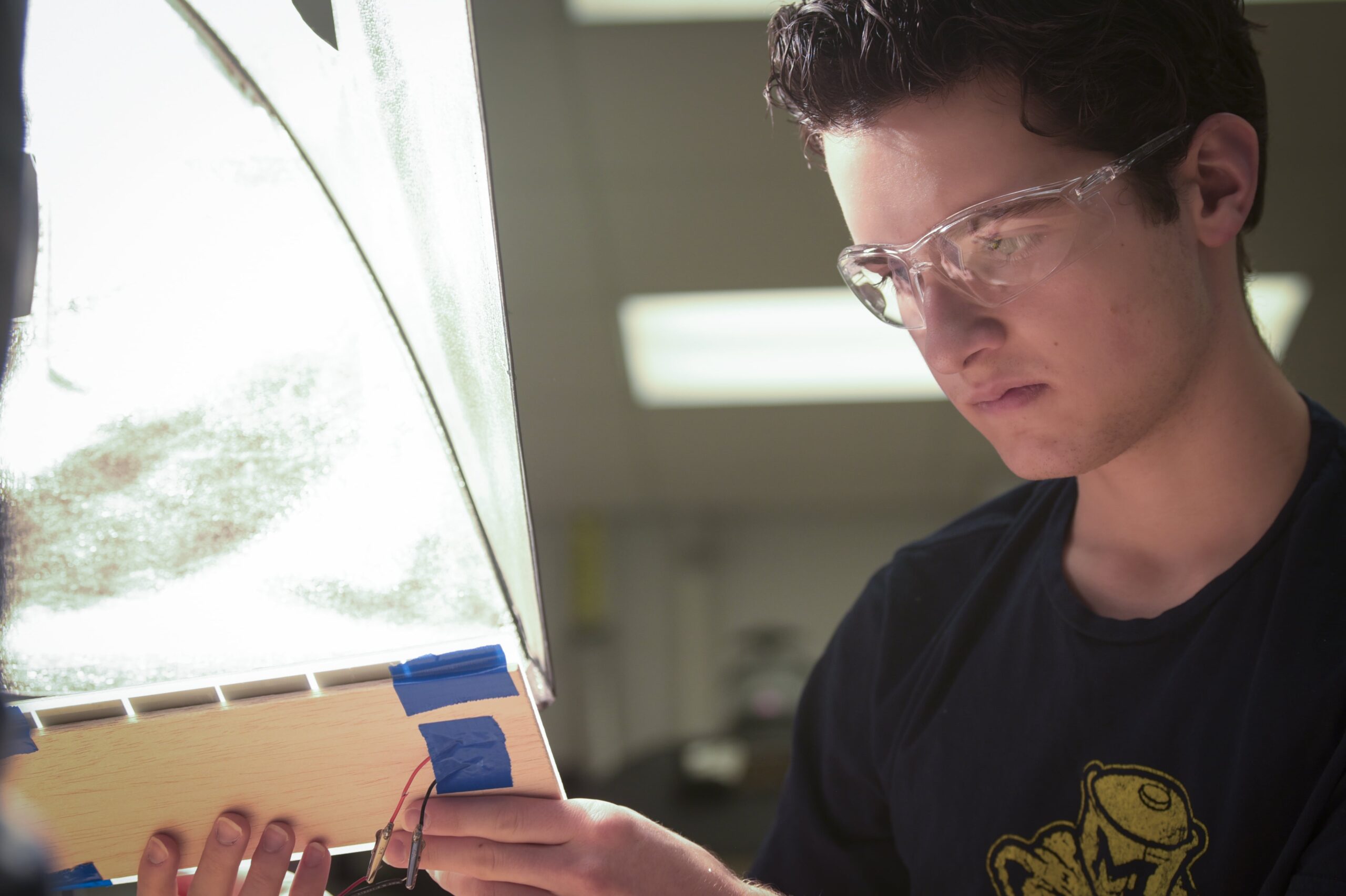 Student inspecting solar panel board and wires