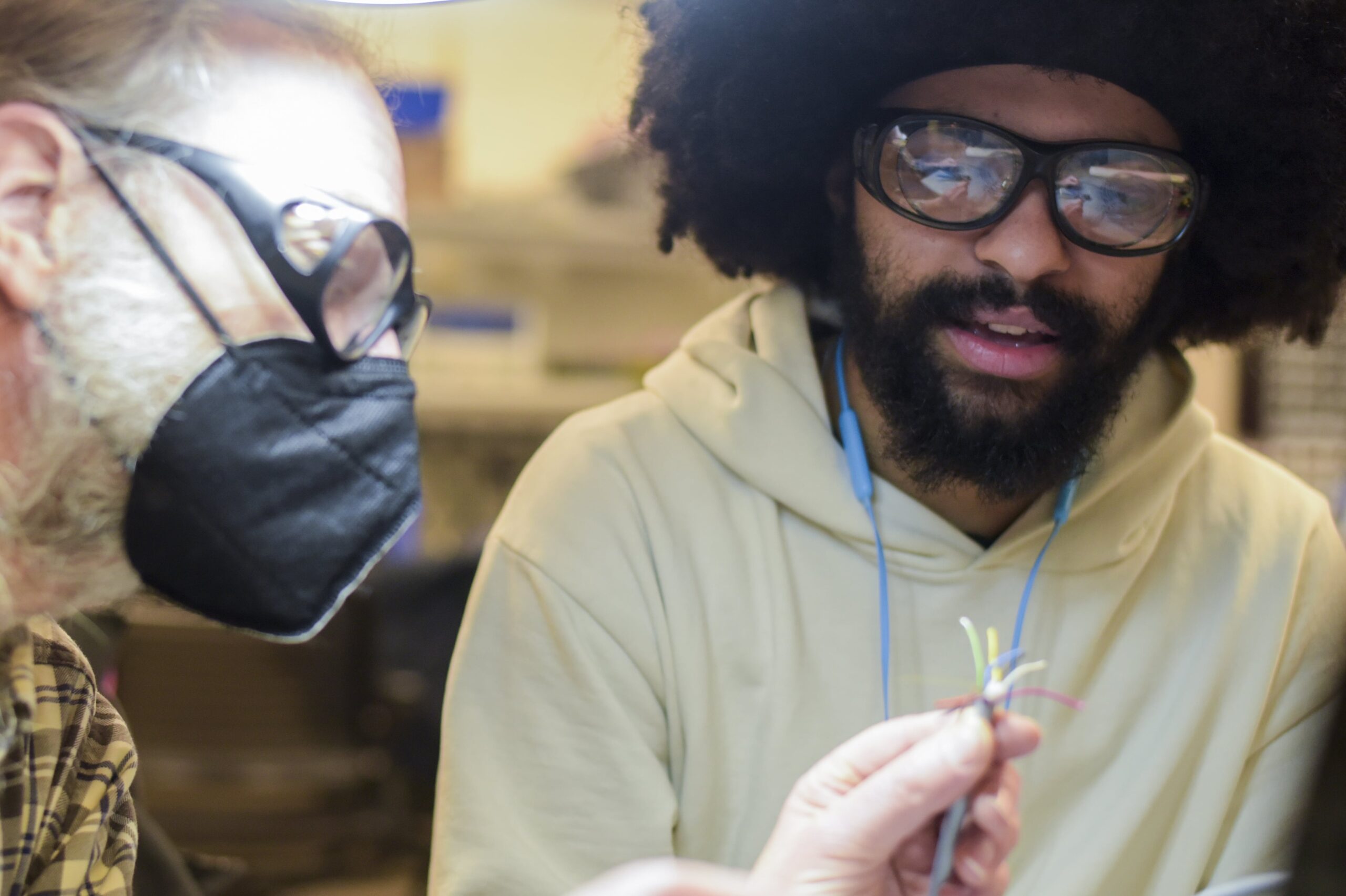 Instructor and Student wearing safety goggles inspecting wires closely