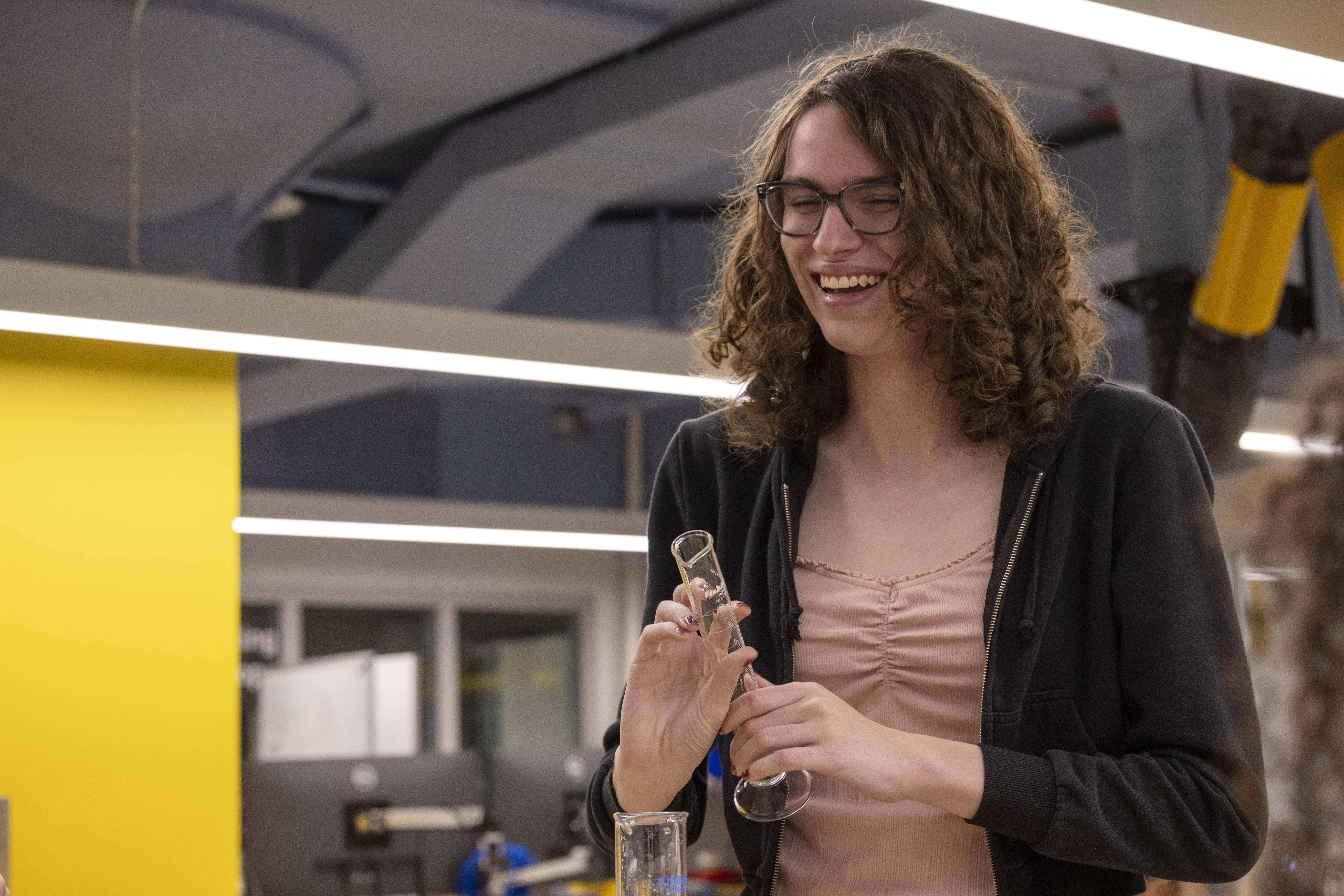 Team of students in lab attire working on experiment together