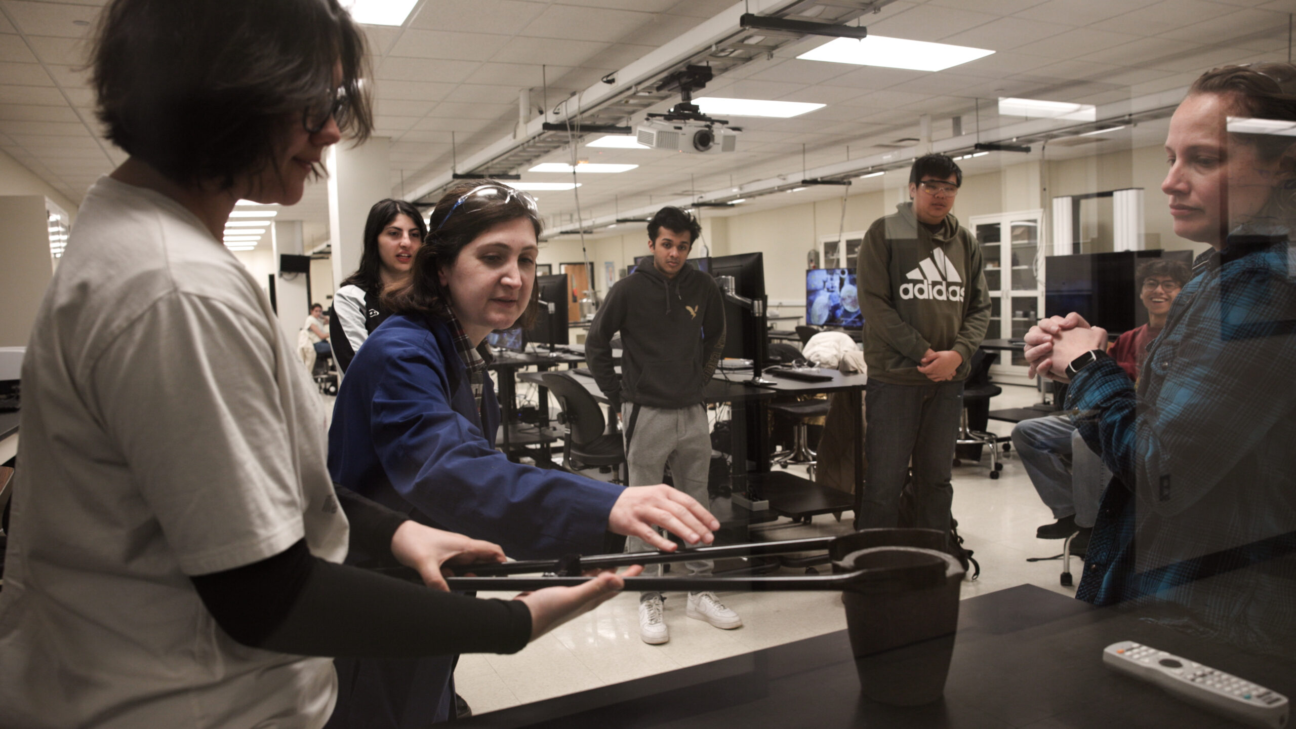Black toolbox filled with colorful parts on table in front of classroom