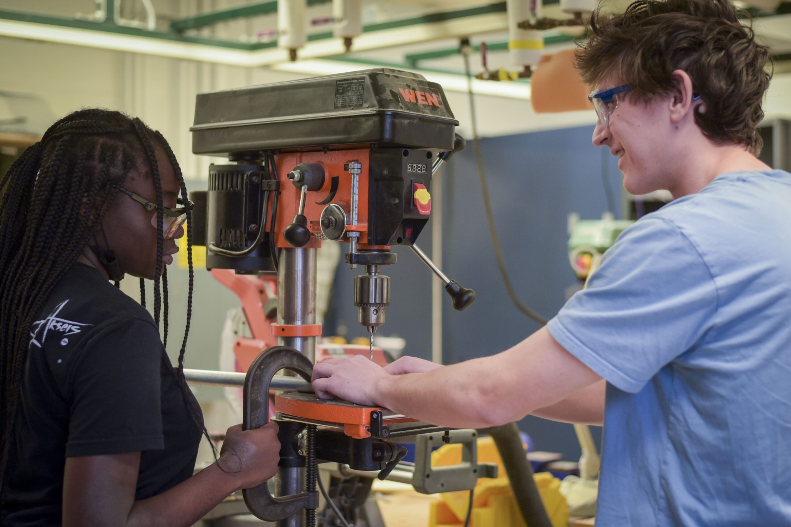 Black toolbox filled with colorful parts on table in front of classroom