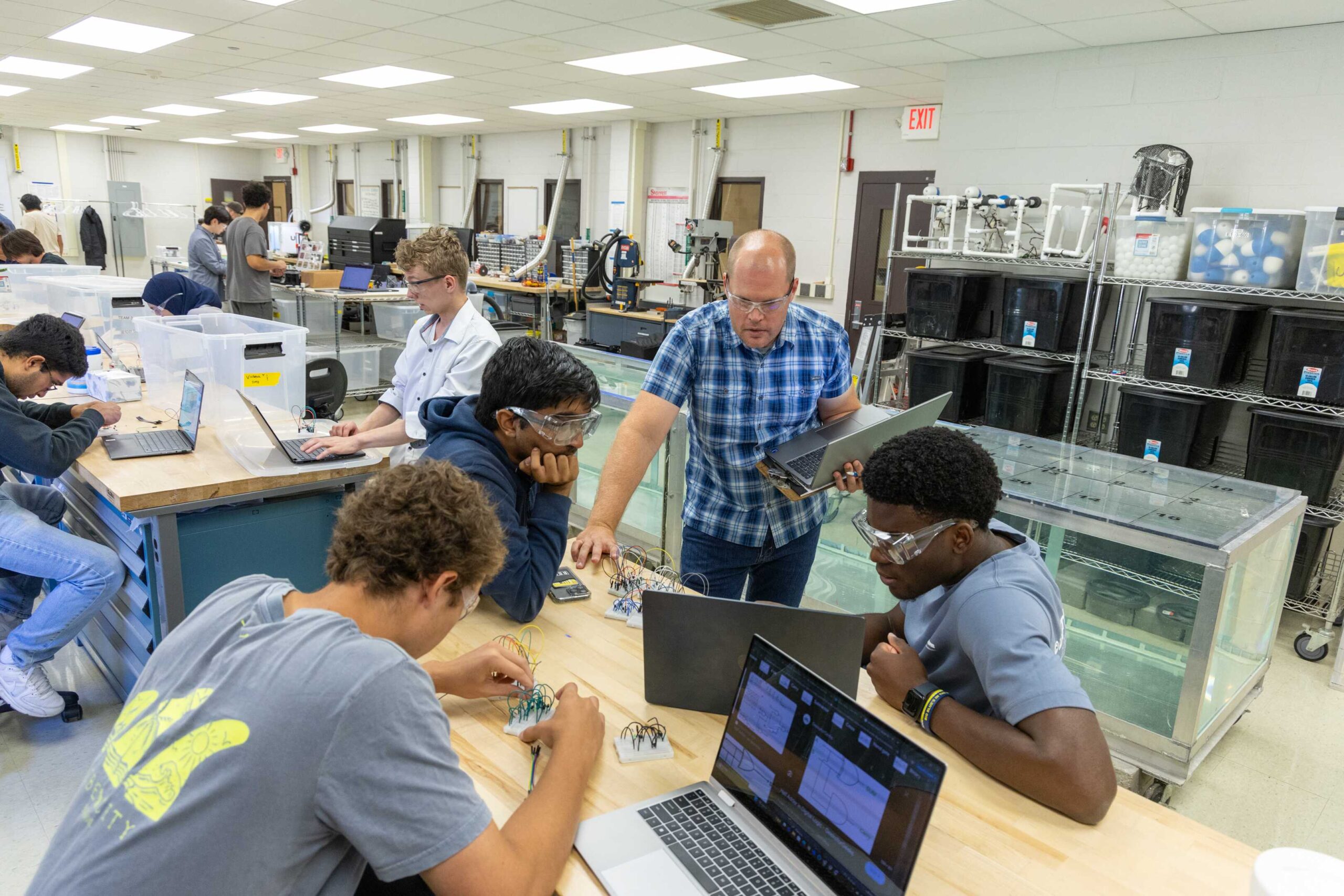 three students testing lab equipment