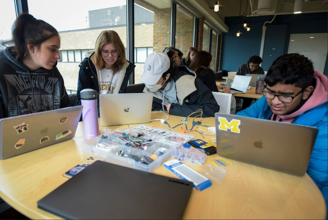 three students working on experiment in lab