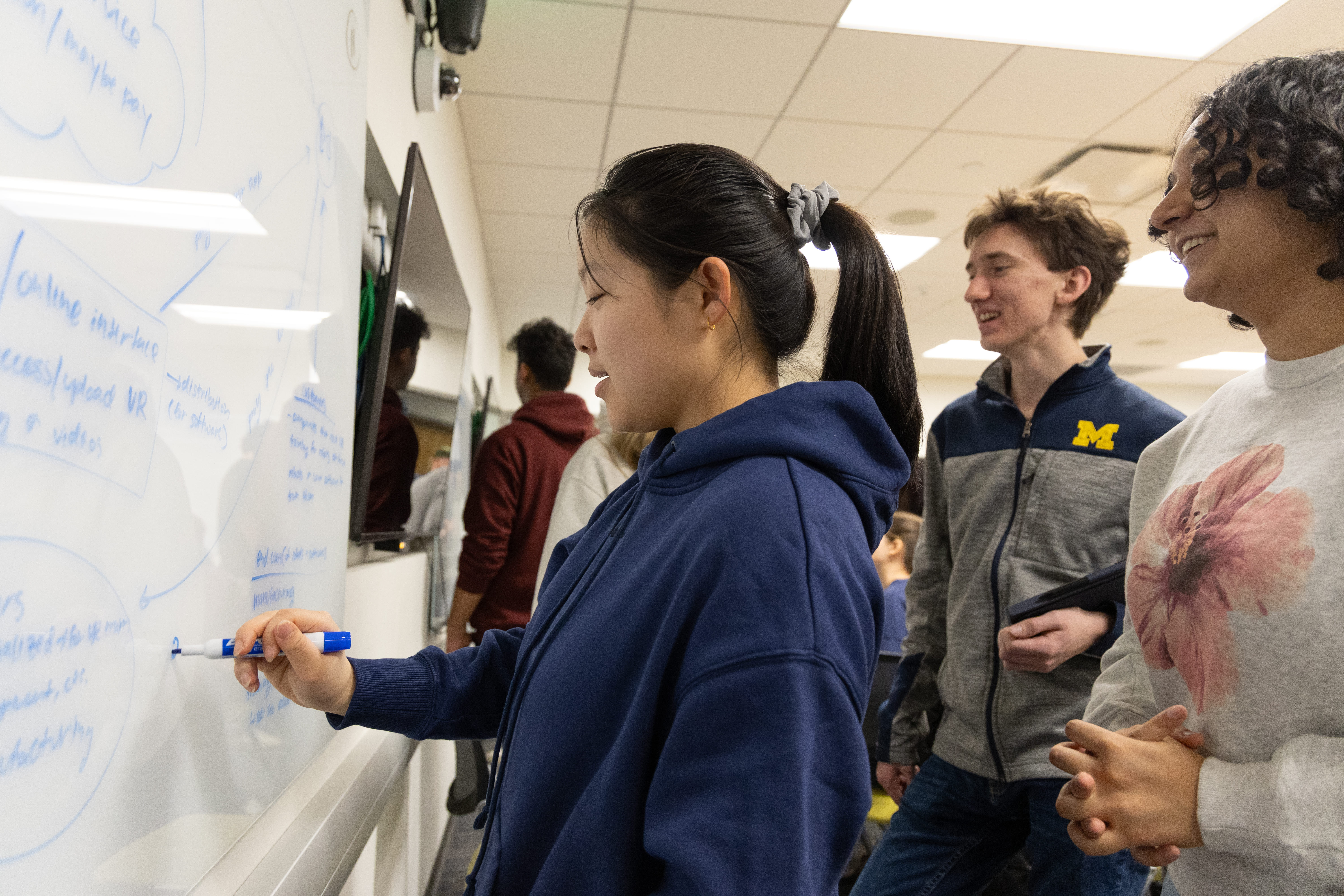 Drawing of a robot holding sign that says “I love ENGR 100” on whiteboard