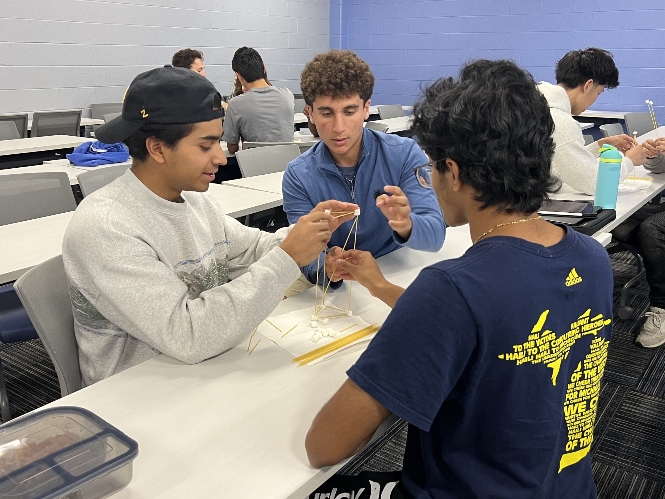 Two students looking at laptop while one points towards something on screen
